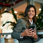 A young girl is using the mobile