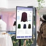A man viewing cloud based digital signage displays inside a modern shopping store