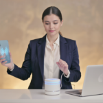 A confident UK businesswoman using a smartphone and a virtual assistant device in a modern office, symbolizing voice search optimization for 2026 UK businesses.