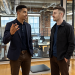 Zak and Adam collaborating professionally in a modern UK office, expressing teamwork and engagement around managed IT services for small businesses.