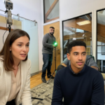 Two UK professionals mid-discussion in an office, reviewing an IT project and addressing issues collaboratively.