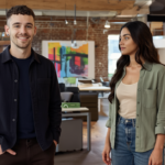 Adam and Sara in a UK office discussing brand identity, showing natural engagement and professional casual attire.