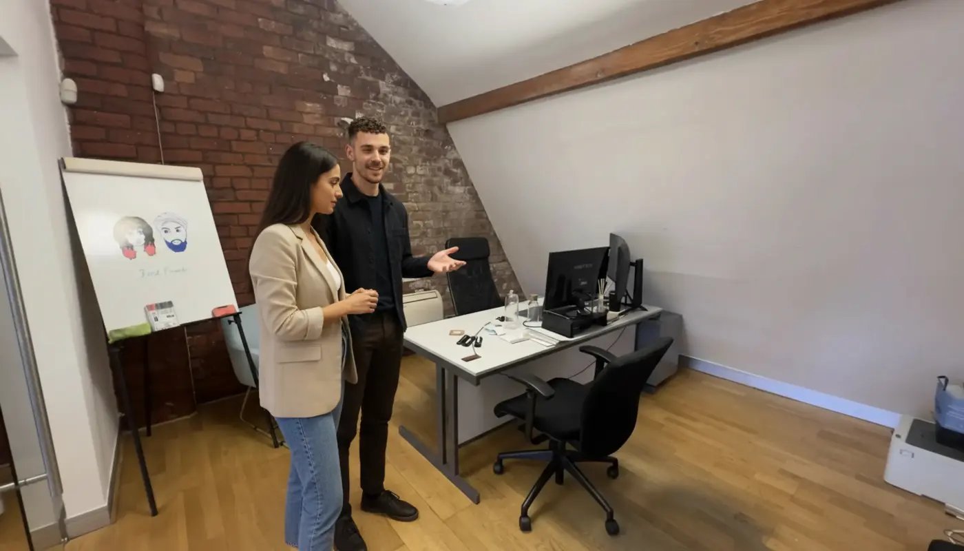 Adam and Sara collaborating in a real UK office, discussing website planning.